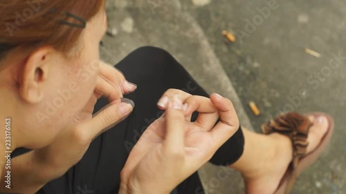 Beautiful Leady cleans her fingernails photo