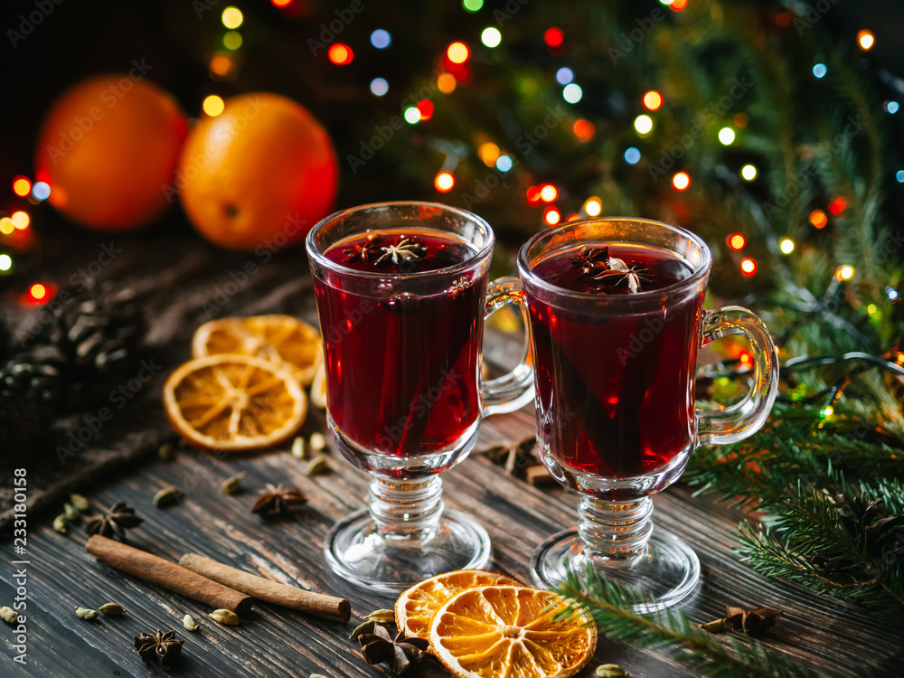 mulled wine in glasses on the table decorated with a Christmas tree. Orange slices, anise stars, cardamom, cinnamon and cloves mulled wine in glasses on the table decorated with a Christmas tree. Orange slices, anise stars, cardamom, cinnamon and cloves