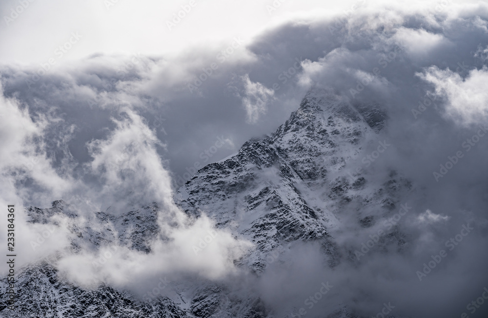 Mountain peeks surrounded in clouds. Concept - mountaineering, mountains, the pursuit of the peaks, the top Mountain peeks surrounded in clouds. Concept - mountaineering, mountains, the pursuit of the peaks, the top
