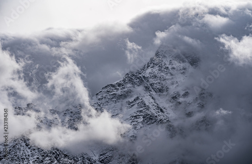 Mountain peeks surrounded in clouds. Concept - mountaineering, mountains, the pursuit of the peaks, the top