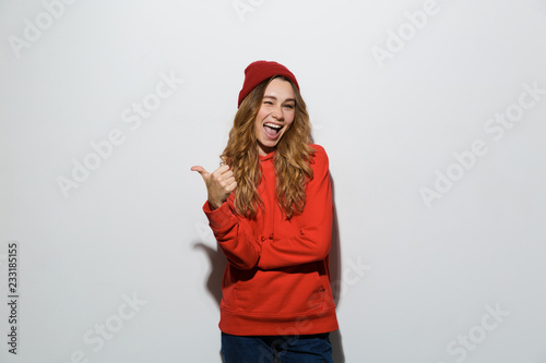 Image of adorable woman in basic clothing laughing and gesturing at camera, isolated over white background