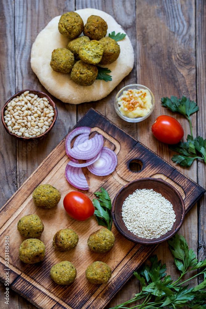falafel with pita and vegetable salad and hummus with pine nuts falafel with pita and vegetable salad and hummus with pine nuts