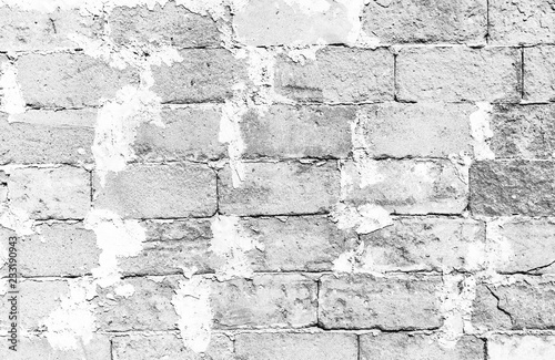 Simple grungy white brick wall surface with excess cement uniting the large concrete block bricks as seamless pattern texture background.