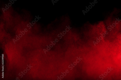 Red powder explosion on black background. Freeze motion of Red dust particles splash.