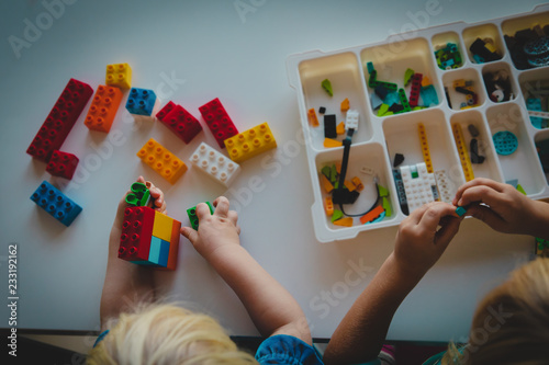 kids play with plastic blocks, building robot at school lesson photo