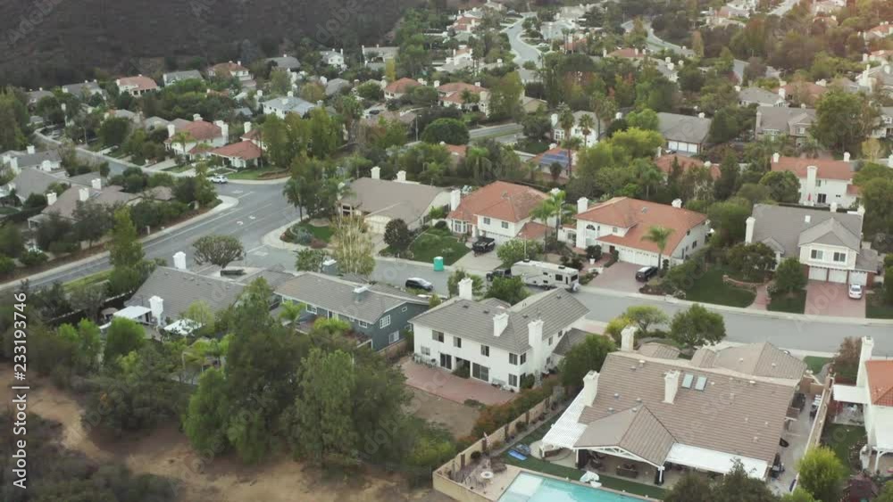 The Sunset over a residential area in between green mountiains in Southern California