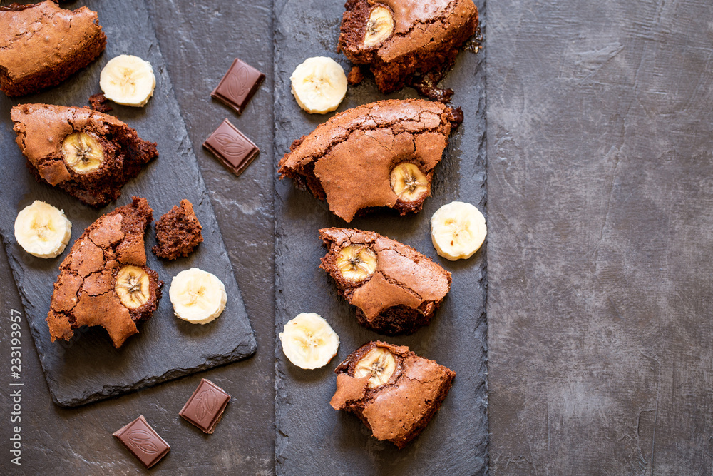 chocolate brownie with banana on shale plates on dark background chocolate brownie with banana on shale plates on dark background