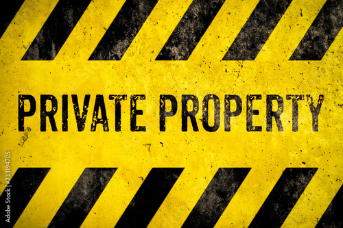 Private property warning sign stencil with yellow and black stripes painted over concrete wall cement texture background. Concept for do not enter the area, caution, danger, no trespassing.