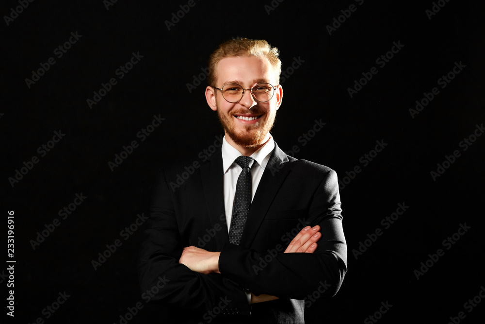 Close up portrait of successful man with beard in glasses keeping arms crossed and smiling on black background. Startup and business concept. Close up portrait of successful man with beard in glasses keeping arms crossed and smiling on black background. Startup and business concept.