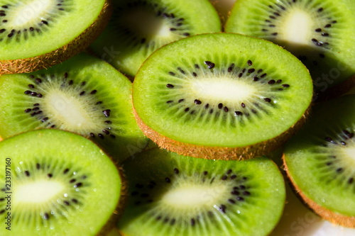Sliced green fresh kiwi fruit pieces lying on table, flat lay view, healthy diet