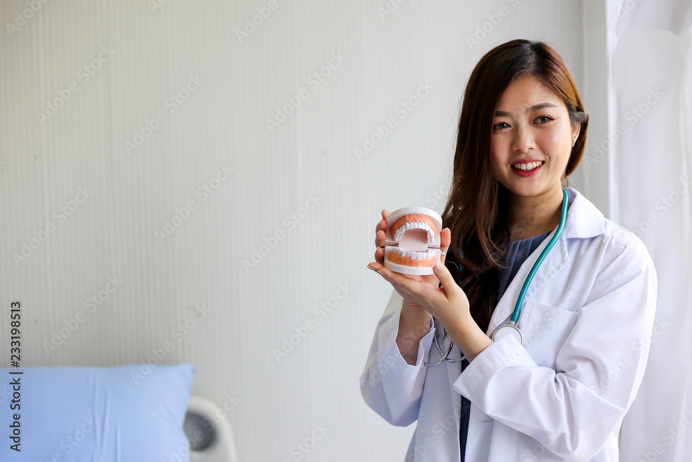 Beautiful woman dentist doctor pointing teeth model,dental checking concept. Beautiful woman dentist doctor pointing teeth model,dental checking concept.