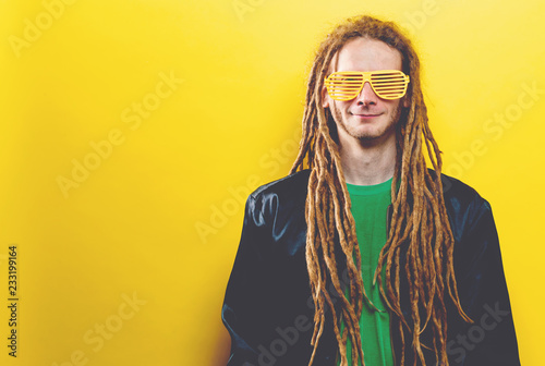 Funky fashion man with dreadlocks on a solid colored background