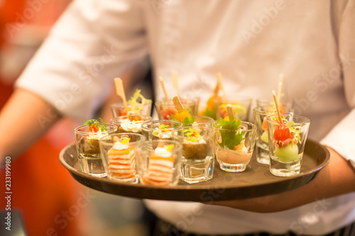 Waiters carrying plates with meat dish at a wedding.Crab meat appetizer served on Cucumber slices.Food arrangements for welcoming the guest of honor.Waiter serving cocktails on a tray.