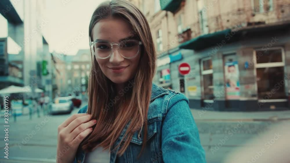 Lifestyle selfie portrait of young positive woman with glasses having fun and taking selfie in city center smile girl feel happy street smartphone vacation positive fashion close up Lifestyle selfie portrait of young positive woman with glasses having fun and taking selfie in city center smile girl feel happy street smartphone vacation positive fashion close up