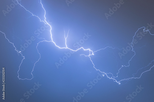 A lightning bolt creeps through the sky. These so called anvil crawlers are horizontal, tree-like, lightning discharges . They appear along the underside of the anvil portions of a thunderstorm.