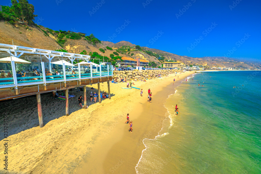 Naklejka premium Malibu, Kalifornia, Stany Zjednoczone - 7 sierpnia 2018: malowniczy nadmorski krajobraz z górami Santa Monica, farmą Malibu i turkusowym morzem popularnej plaży Carbon lub plaży miliardera dla domów VIP.