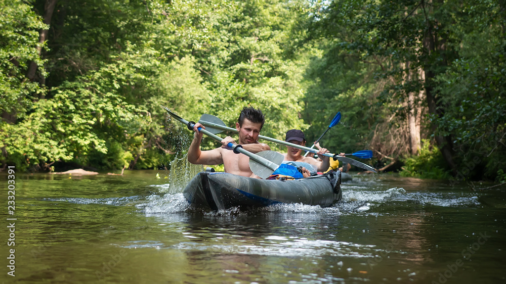 Athlete men in kayak with oars on wild river Athlete men in kayak with oars on wild river