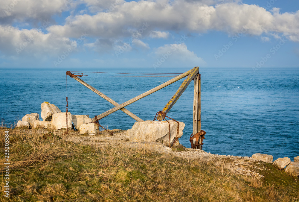 Old disused wooden crane used to move Portland stone against coastal background taken in Portland, Dorset, UK on 13 March 2016 Old disused wooden crane used to move Portland stone against coastal background taken in Portland, Dorset, UK on 13 March 2016