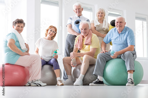 Happy senior people sitting on balls after physical classes in the studio photo