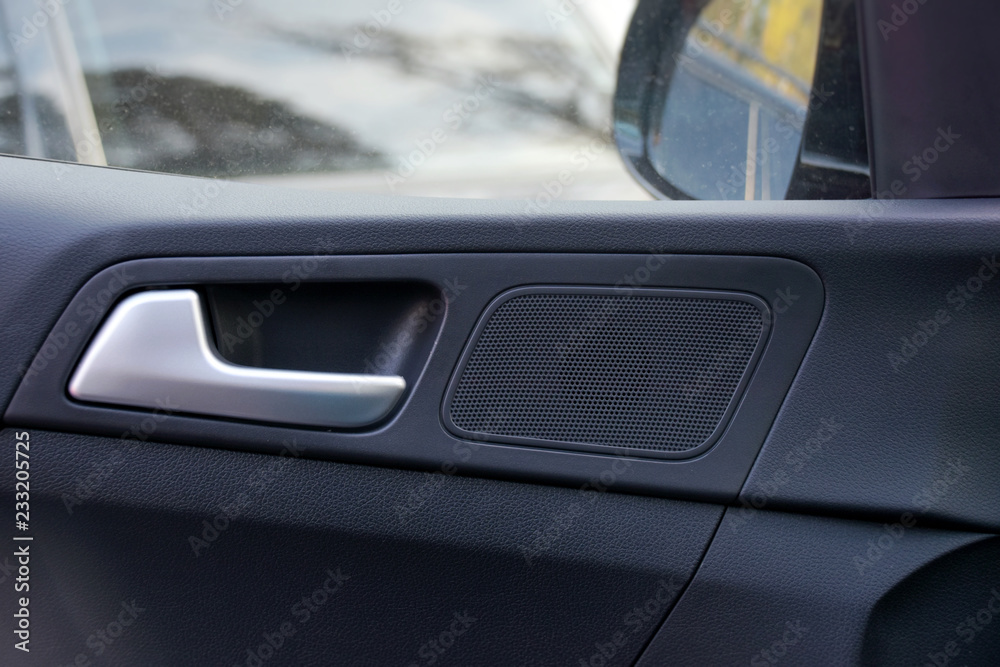 Car interior. Black plastic automobile door with chrome door handle, car window and mirror