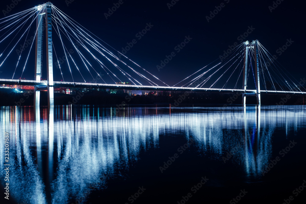 Bridge over the Yenisei river, with night lighting. The concept of the city at night.