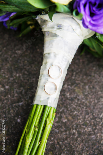 bridal bouquet of purple and beige colors and wedding rings close up