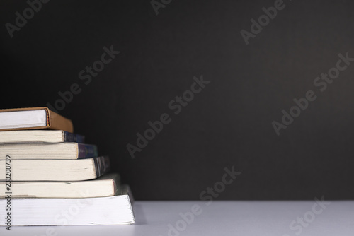 Book stack on black wall, Copy space.