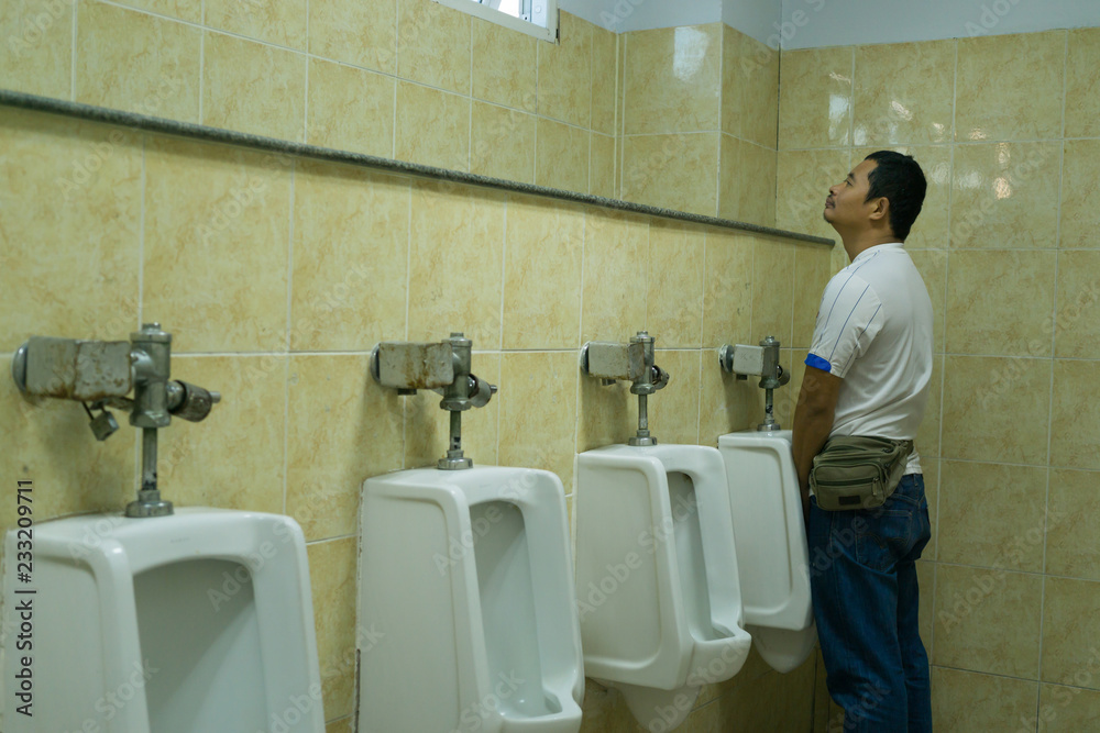 A man is urinating in public bathrooms 