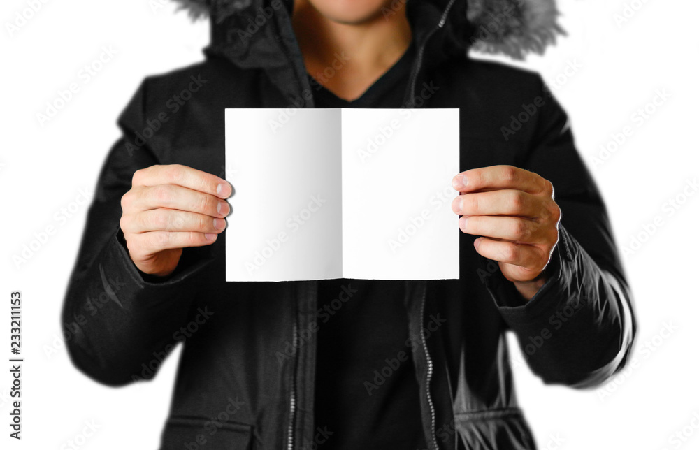 A man in a warm winter jacket holding a white leaflet. Blank paper. Close up. Isolated on white background A man in a warm winter jacket holding a white leaflet. Blank paper. Close up. Isolated on white background