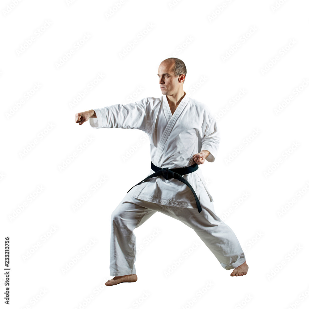 On an isolated white background, an athlete trains formal karate exercises On an isolated white background, an athlete trains formal karate exercises