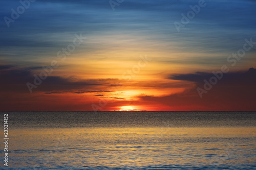 sunset over the ocean on clear evening