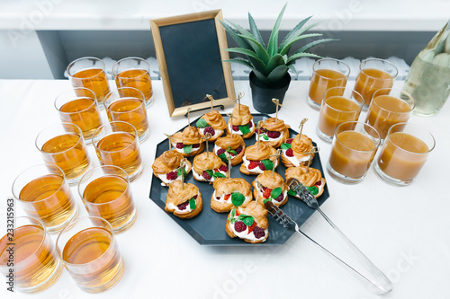 sweet catering with berry cackes and juice at white table photo