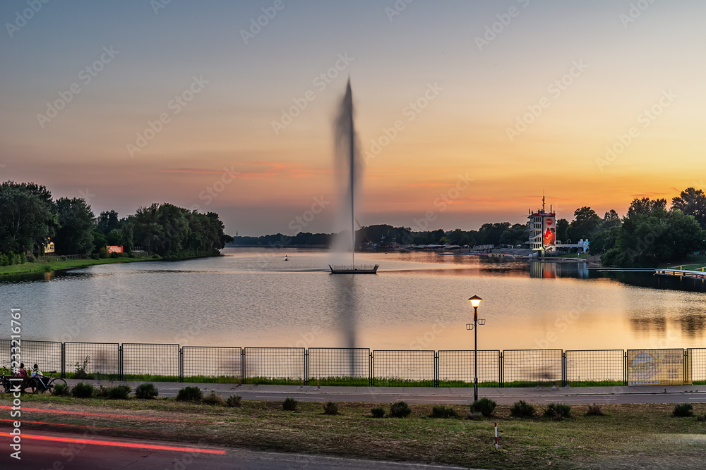 Naklejka premium Belgrade, Serbia - 20 June, 2018: Lake and geyser by sunset Ada Ciganlija - Belgrade