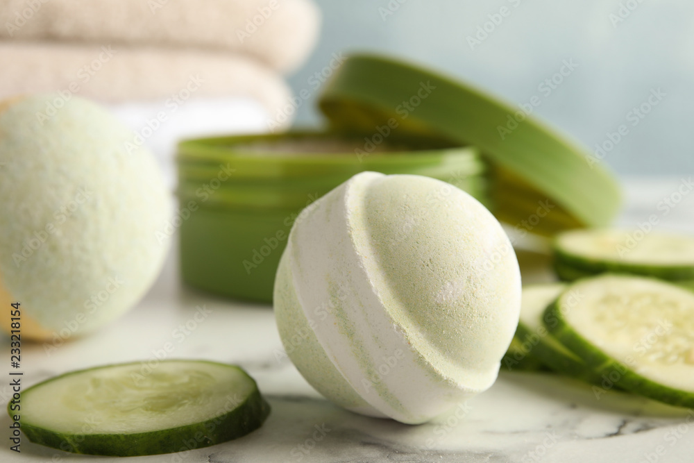 Bath bomb and cucumber slices on marble table Bath bomb and cucumber slices on marble table