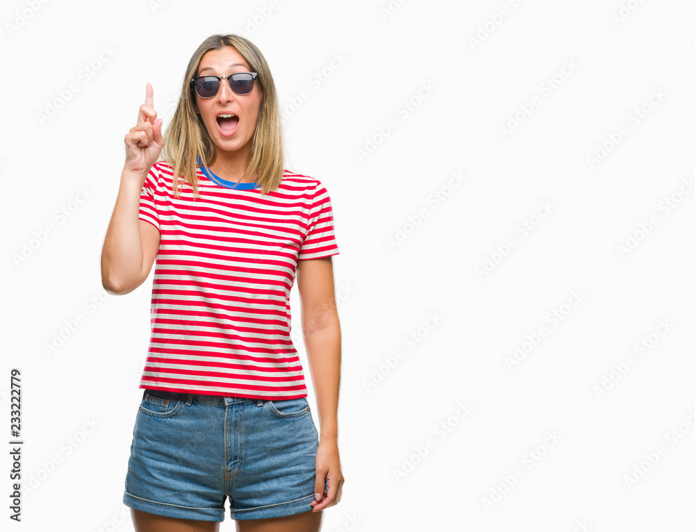 Young beautiful woman wearing sunglasses over isolated background pointing finger up with successful idea. Exited and happy. Number one. Young beautiful woman wearing sunglasses over isolated background pointing finger up with successful idea. Exited and happy. Number one.