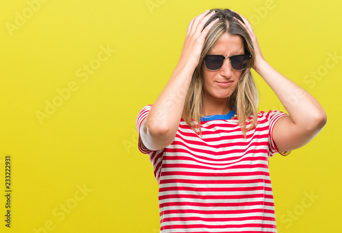 Young beautiful woman wearing sunglasses over isolated background suffering from headache desperate and stressed because pain and migraine. Hands on head.