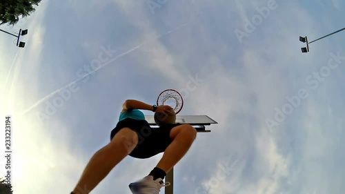 Slow motion of a basketball player acrobatic shot seen from below photo