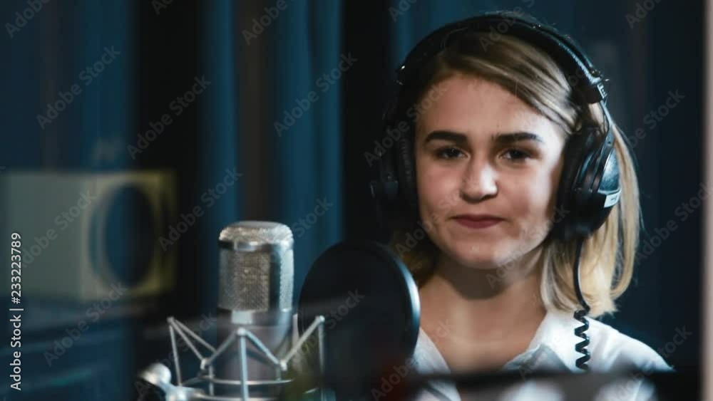 Cute singer young woman training to make music in professional studio sound microphone smile beautiful expression young equipment female pop voice artist human star talent work record girl close up Cute singer young woman training to make music in professional studio sound microphone smile beautiful expression young equipment female pop voice artist human star talent work record girl close up