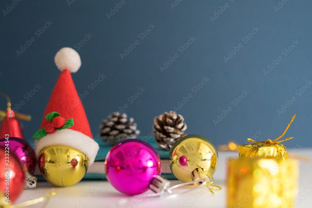 Christmas concept with copy space.Ornament balls, Santa Claus hat and note book with blue background.