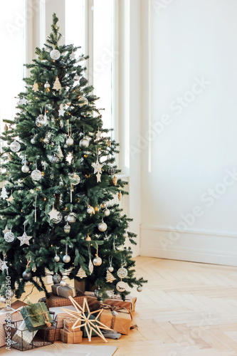 Decorated Christmas tree with gifts in bright living room, Scandinavian interior