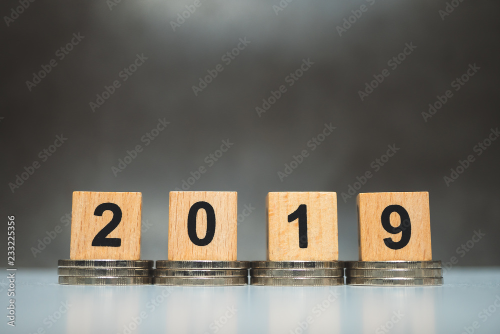 Obraz premium Wooden block year 2019 with stack coins using as business and financial concept