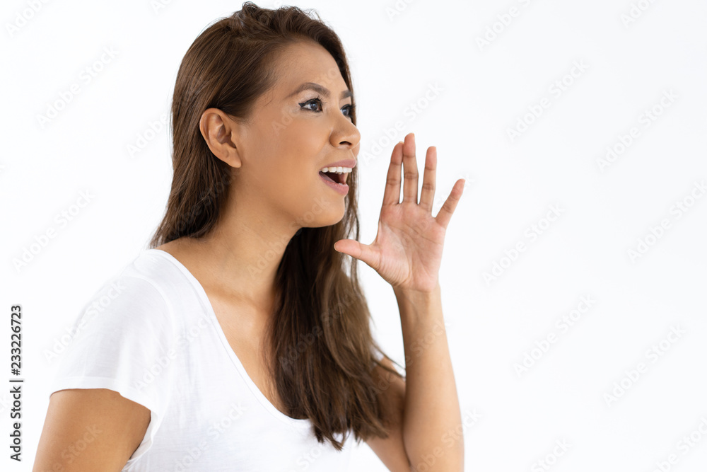 Amazed girl announcing important event. Side view of young woman smiling and shouting loud hand at mouth. Announcement or event concept Amazed girl announcing important event. Side view of young woman smiling and shouting loud hand at mouth. Announcement or event concept