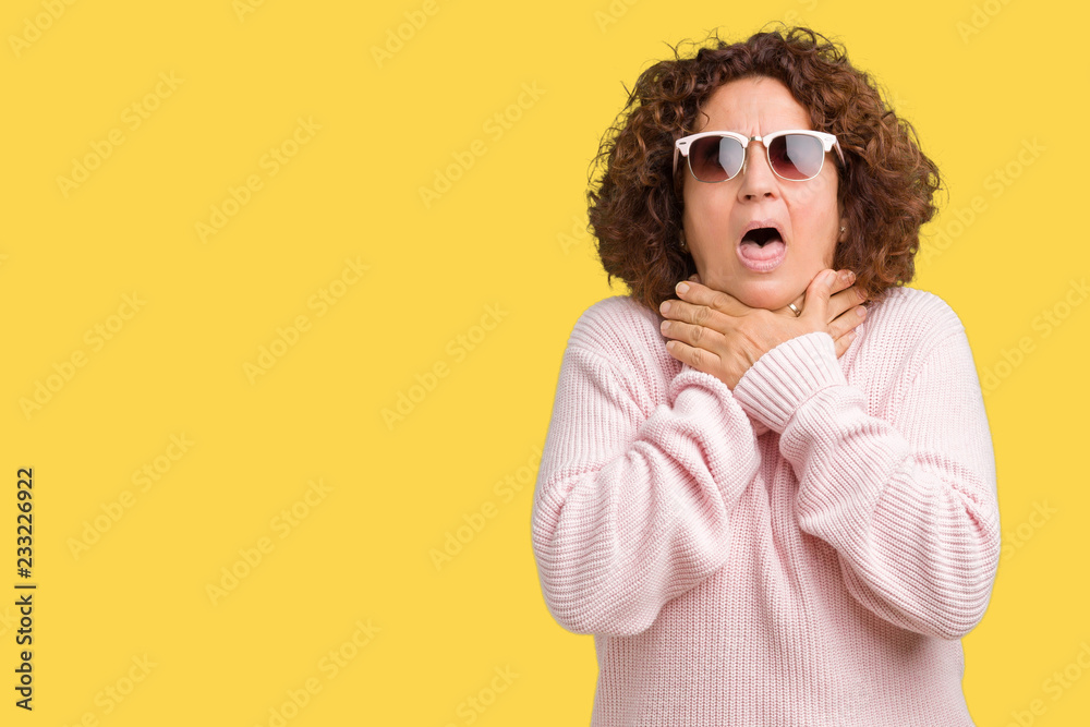 Beautiful middle ager senior woman wearing pink sweater and sunglasses over isolated background shouting and suffocate because painful strangle. Health problem. Asphyxiate and suicide concept. Beautiful middle ager senior woman wearing pink sweater and sunglasses over isolated background shouting and suffocate because painful strangle. Health problem. Asphyxiate and suicide concept.