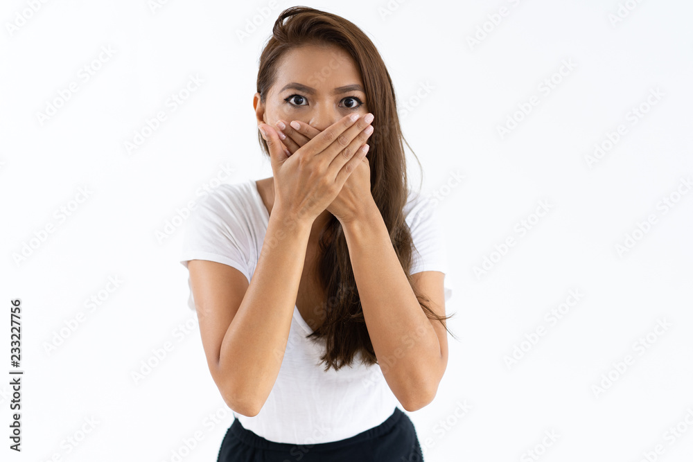 Scared girl shocked by news. Beautiful young woman with wide eyes covering mouth by both hands. Shock concept Scared girl shocked by news. Beautiful young woman with wide eyes covering mouth by both hands. Shock concept