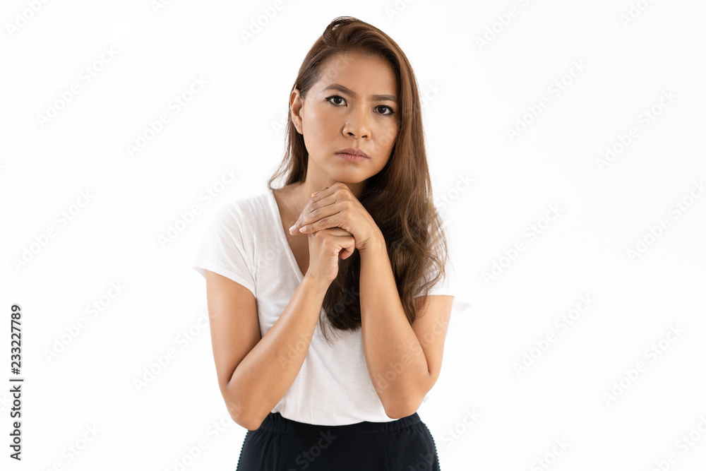 Serious concerned young woman clasping hands at chin and looking at camera. Worried girl waiting for important news or asking for help. Anxiety concept Serious concerned young woman clasping hands at chin and looking at camera. Worried girl waiting for important news or asking for help. Anxiety concept