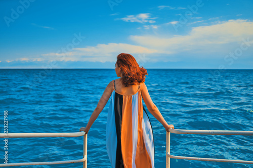 Behind girl on pier.