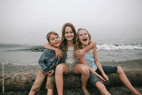 Cousins and sibling kids playing on the beach on cloudy day