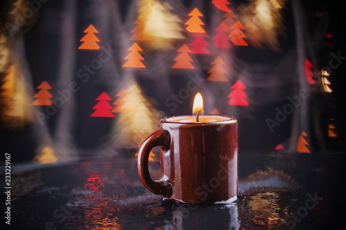 Burning red tea light candle on illumination decoration colorful glitter bokeh background. New Year, Christmas festive greeting card, banner, poster design element. burning candle and many colorful l