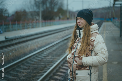 The girl on the railway track in cold weather. Nice girl on a railway road in an autumn day photo