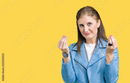 Beautiful middle age mature woman wearing fashion leather jacket over isolated background Doing money gesture with hand  asking for salary payment  millionaire business